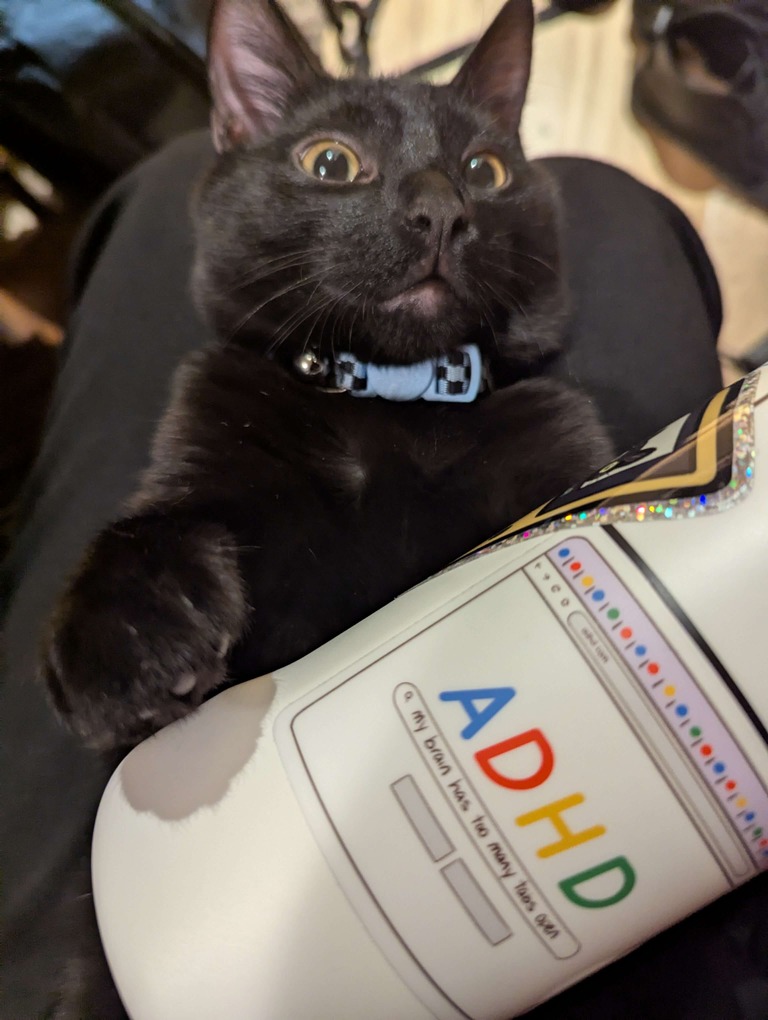 A cat with a water bottle and sticker that says, ADHD: my brain has too many tabs open